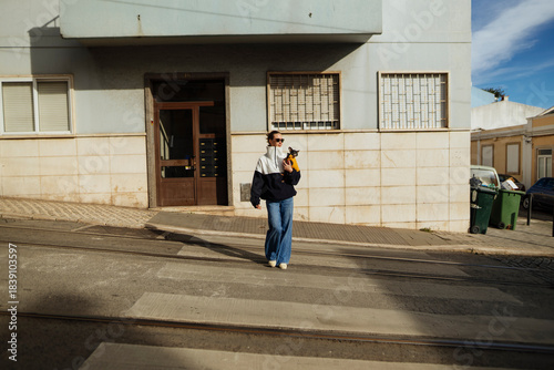 Young woman pausing on urban sidewalk, commuter moment