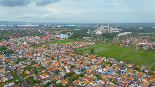 фотографія Cement factory in Cilacap dominates this aerial view looming large beside the villages quiet existence