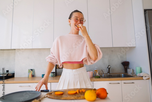 Lively scene with woman savoring orange and smiling broadly