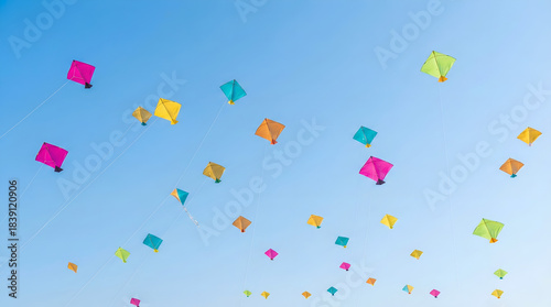 Colorful makarsankranti kites flying high in a bright clear blue sky with crisp strings and vibrant festive colors for modern celebration banners and seasonal creative design