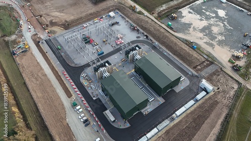 Aerial view of the industrial buildings standing starkly against the surrounding brown fields and newly constructed roads, Sutton Bridge, United Kingdom.