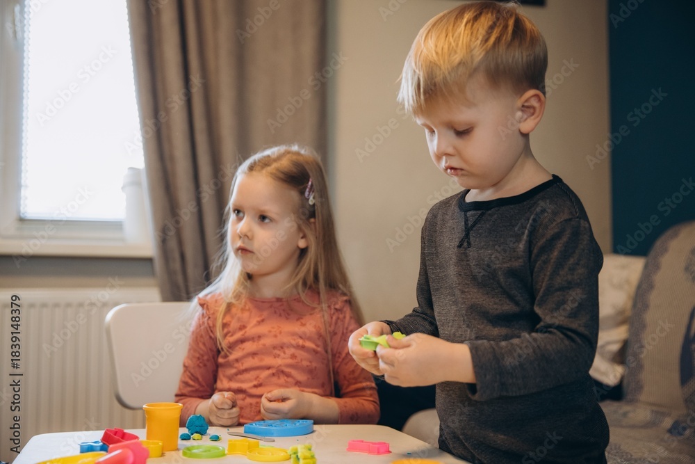 Obraz premium Children playing with colorful playdough at home