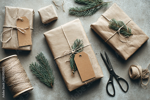 Neutral Eco-Friendly Holiday Gift Wrapping Flat Lay with Kraft Paper, Twine and Evergreen on Light Textured Background