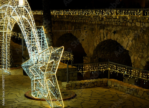Christmas lights backdrop at Peñiscola Castle with stone arches and illuminated Christmas star