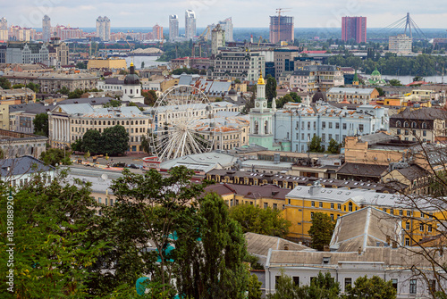 Podil cityscape seen from Andriyivskyy Descent with the Kontraktova Square Ferris wheel and modern buildings in the background