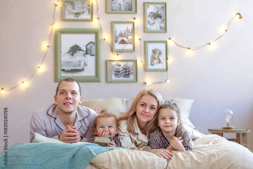 Fototapeta premium A happy family and pets in a bedroom at home on Christmas morning. New Year's.