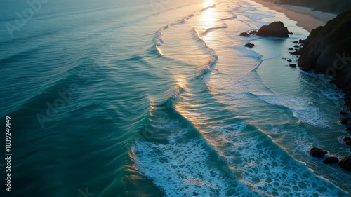 Waves roll onto a beach during sunset on a clear evening at a coastal area