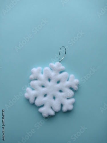 Snowflake Christmas tree toy on a blue background.