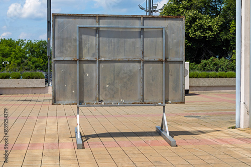 Empty aluminium silver metal panel from behind outside in city street