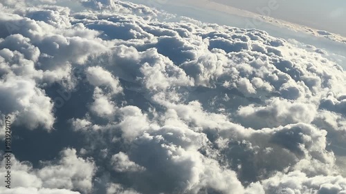 Puffy formations slide past the window, giving a dynamic aerial perspective