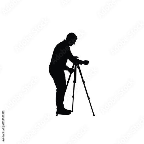 Photographer adjusting camera on tripod silhouette