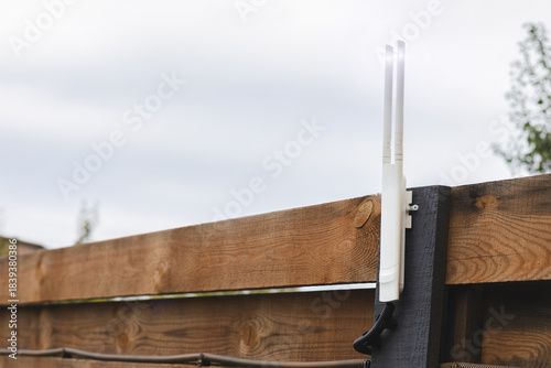 Wi-Fi router outdoor on fence near the house.  Close up photo.