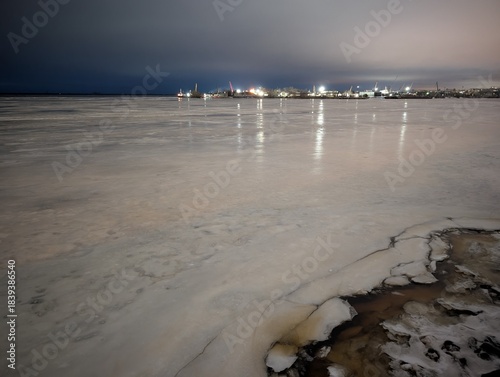 Frozen Harbor At Dusk Smooth Ice Leading To Lit Skyline And Piers Wide Glazed Surface Reflects Distant
