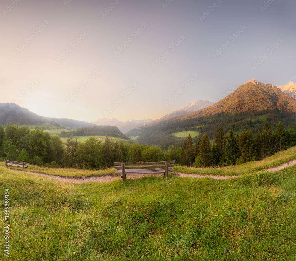 Fototapeta premium Meadow with road and bench during sunset in Berchtesgaden National Park