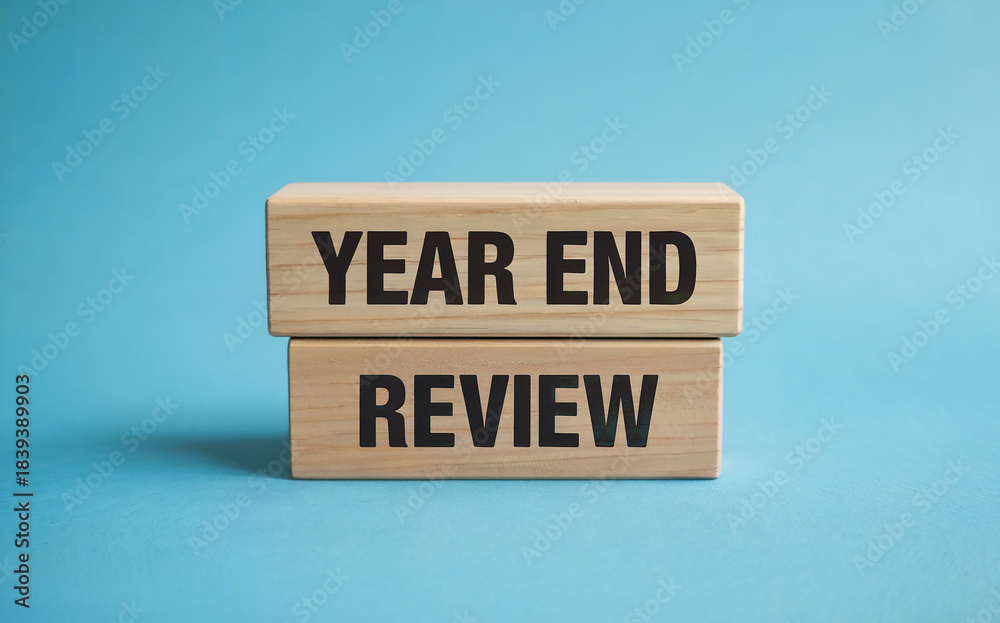 Naklejka premium Year End Review Text on Stacked Wooden Blocks for Business