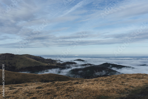 low clouds over the mountains in cold winter with hills 