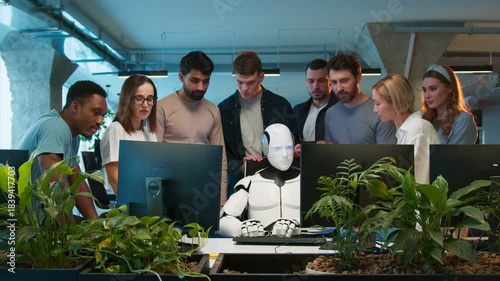 Team of engineers gathered around workstation. Mixed group discussing malfunction while robot sitting idle at center. Developers analyzing issue and sharing concerns. In collaborative tech environment