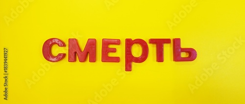Foto Red Cyrillic text with magnetic letters DEATH on a yellow background