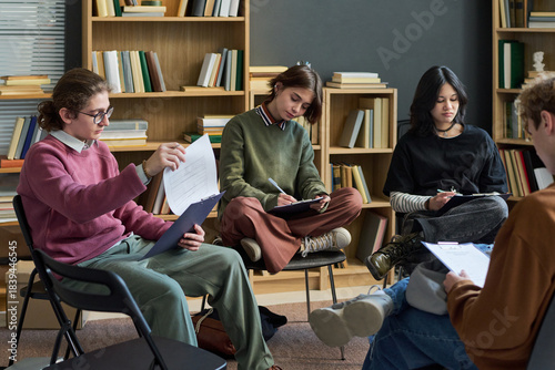 Konstfotografi Group of multiethnic teenagers sitting in circle participating in group therapy