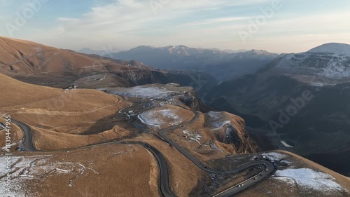 Aerial view of the historic Russia-Georgia Friendship Arch monument situated on a cliff edge near Jvari Pass in the Gudauri mountain area. Early wiinter landscape with beautiful mountains.