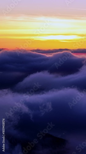 Vertical time lapse above moving fast thick fog, view on beautiful ocean of clouds at sunrise, 
