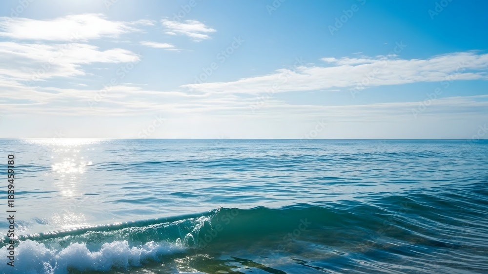 Fototapeta premium Calm Blue Ocean with Gentle Waves Under Bright Sky in Summer