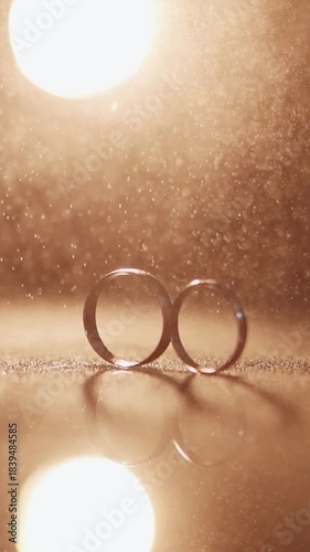 Wedding rings close-up on a dark background with light, as a symbol of love and marriage