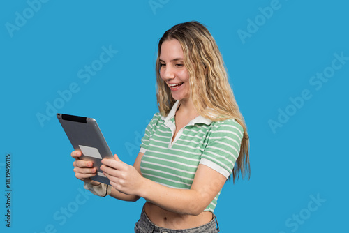 Teenager smiling cheerfully while using digital tablet