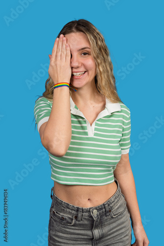 Woman smiling covering eye with rainbow bracelet
