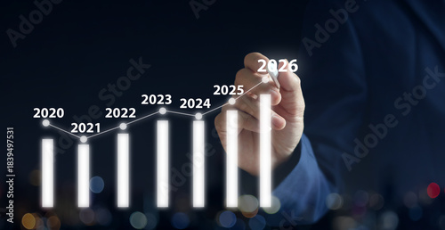 close up businessman hand use stylus pen to write virtual statistic graph about business plan and target of company over black background for future and 2026 new year goal concept