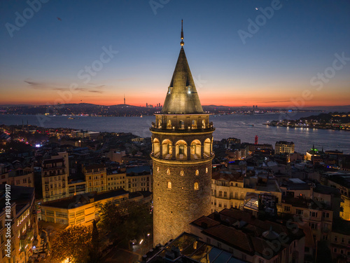 Aerial view of Galata Tower and Istanbul skyline at sunrise over the Bosphorus. The Galata Tower illuminated against the red morning sky, Istanbul, Turkey