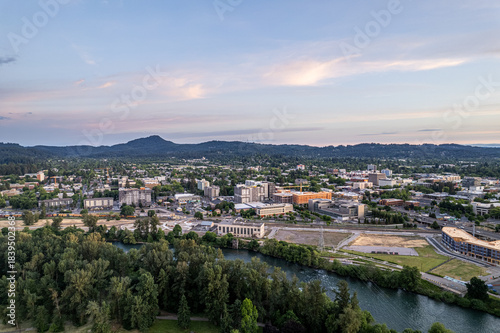 Wallpaper Mural Aerial view of the Willamette River winding through Eugene, with Skinner Butte rising in the distance under a soft, pastel sky, Eugene, Oregon, United States. Torontodigital.ca