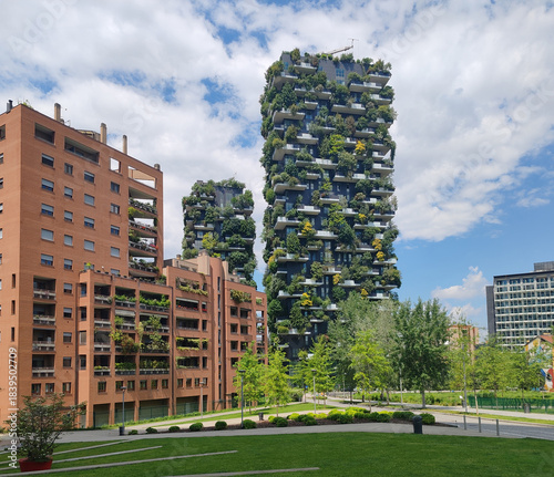 Milan, Italy – May 23, 2025: Modern residential towers of the Bosco Verticale complex rise above a landscaped urban park in the Porta Nuova district