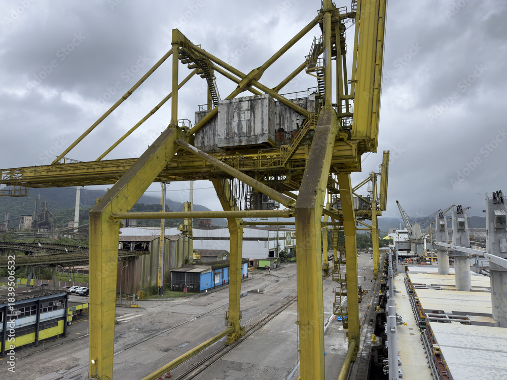 Fototapeta premium port quay with extremely large heavy-duty port cranes designed for handling metal cargo. Industrial harbor landscape with powerful lifting equipment, port infrastructure and maritime logistics