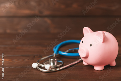 Medical costs, financial concept, health insurance. Stethoscope over dollar bills. Money and piggy bank. Medical care. Health care financial checkup or saving for medical insurance costs concept.