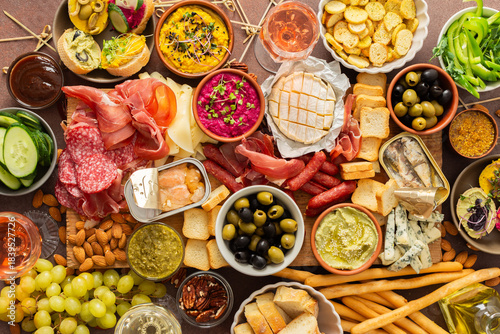 фотографія Enjoy a vibrant charcuterie board filled with assorted cheeses, savory sausages, creamy hummus, nuts, and colorful vegetables