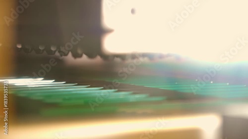 A close-up shot of a modern industrial machine automatically dispensing liquid chocolate filling into green empty molds on a conveyor belt, during the mass production process