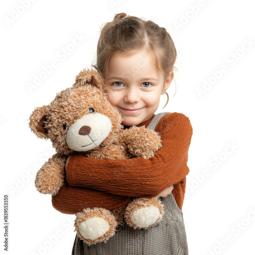 Child Hugs Teddy Bear While Smiling in Simple Indoor Space During Daytime