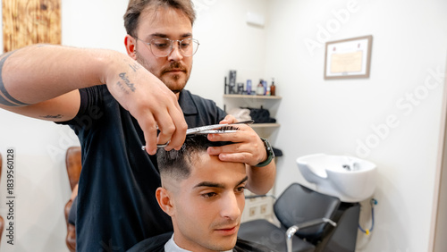 Barber skillfully cutting client's hair in a stylish shop