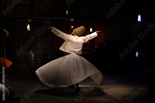 Tableau sur toile The image of a dervish performing a whirling dervish dance against a dark backdrop