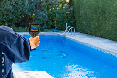 Technician detecting swimming pool leak with thermal camera