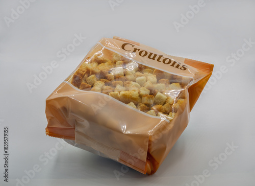 Bag of crunchy croutons closeup on white background.