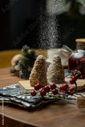 Wallpaper Mural Delightful holiday treats shaped like trees sit on a rustic wooden board, covered in powdered sugar. A warm ambiance surrounds them with festive decorations and cheerful vibes Torontodigital.ca