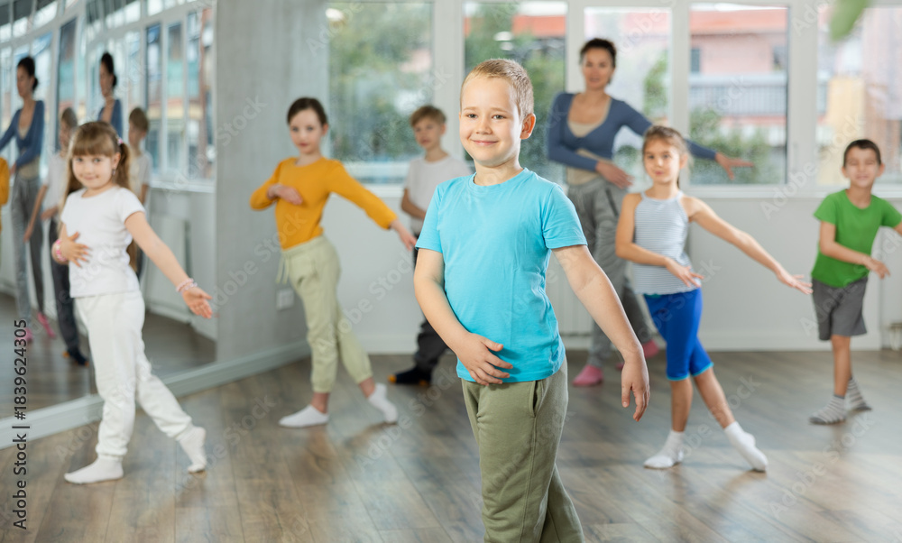 Naklejka premium Boy with friends repeat teaches sequences of movements during training, train to perform electro dance, enjoys active hobby to her favorite music. Unrecognizable female teacher administer conduct