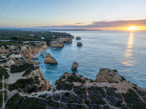 Marinha Beach, Cliffs, Coastline and Atlantic Ocean at Sunrise. Green Trees. Aerial View. Algarve, Portugal