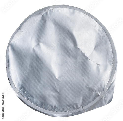 Foto Close-up of a crumpled round foil yogurt lid on an isolated background