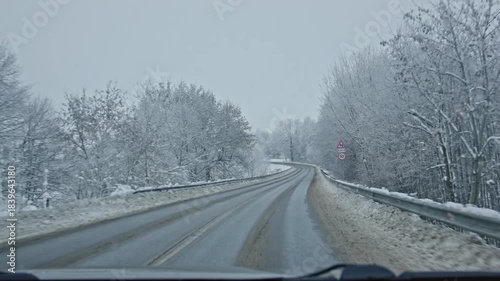 A beautifully serene winter drive along a long and winding road that is surrounded by snowladen trees