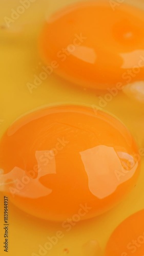raw egg yolks close-up, rotation in circle. fresh eggs for recipe preparation, Turning. vertical video. cooking ingredient