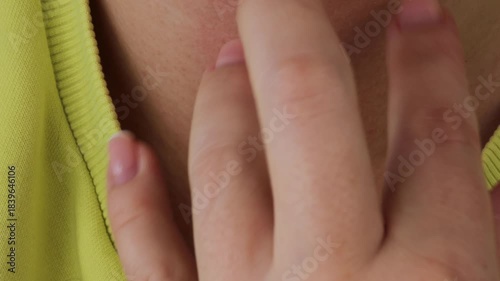 Person scratching neck due to allergy and stress. Red irritated skin shows psychosomatic reaction and contact dermatitis from clothing. Scratching neck reflects discomfort and allergic reaction.