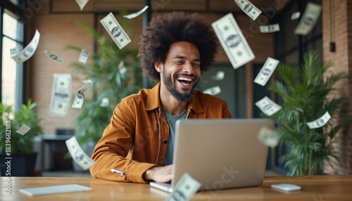 Man laughs using laptop with money falling. He works online, finds financial success, earning wealth. Digital currency and business opportunities bring fortune. Guy celebrates internet income.